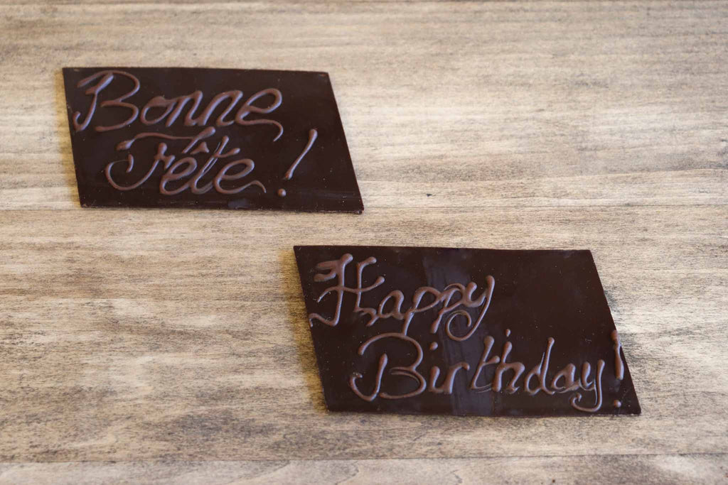 Inscription bonne fête et happy birthday sur une plaque en chocolat